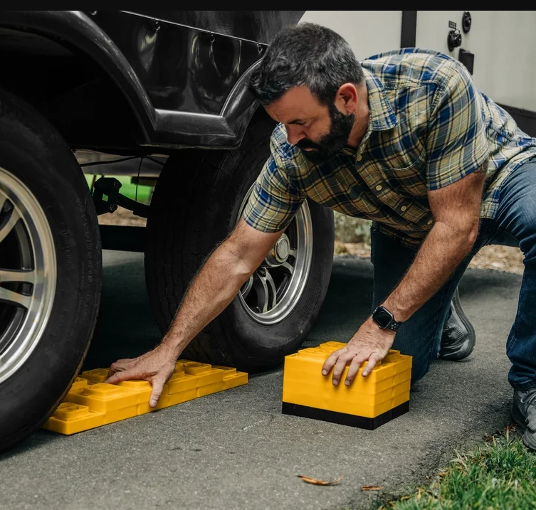 RV owner inspecting leveling jacks before attempting a DIY repair